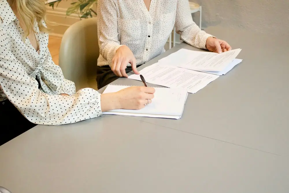 Client signing legal documents with her lawyer